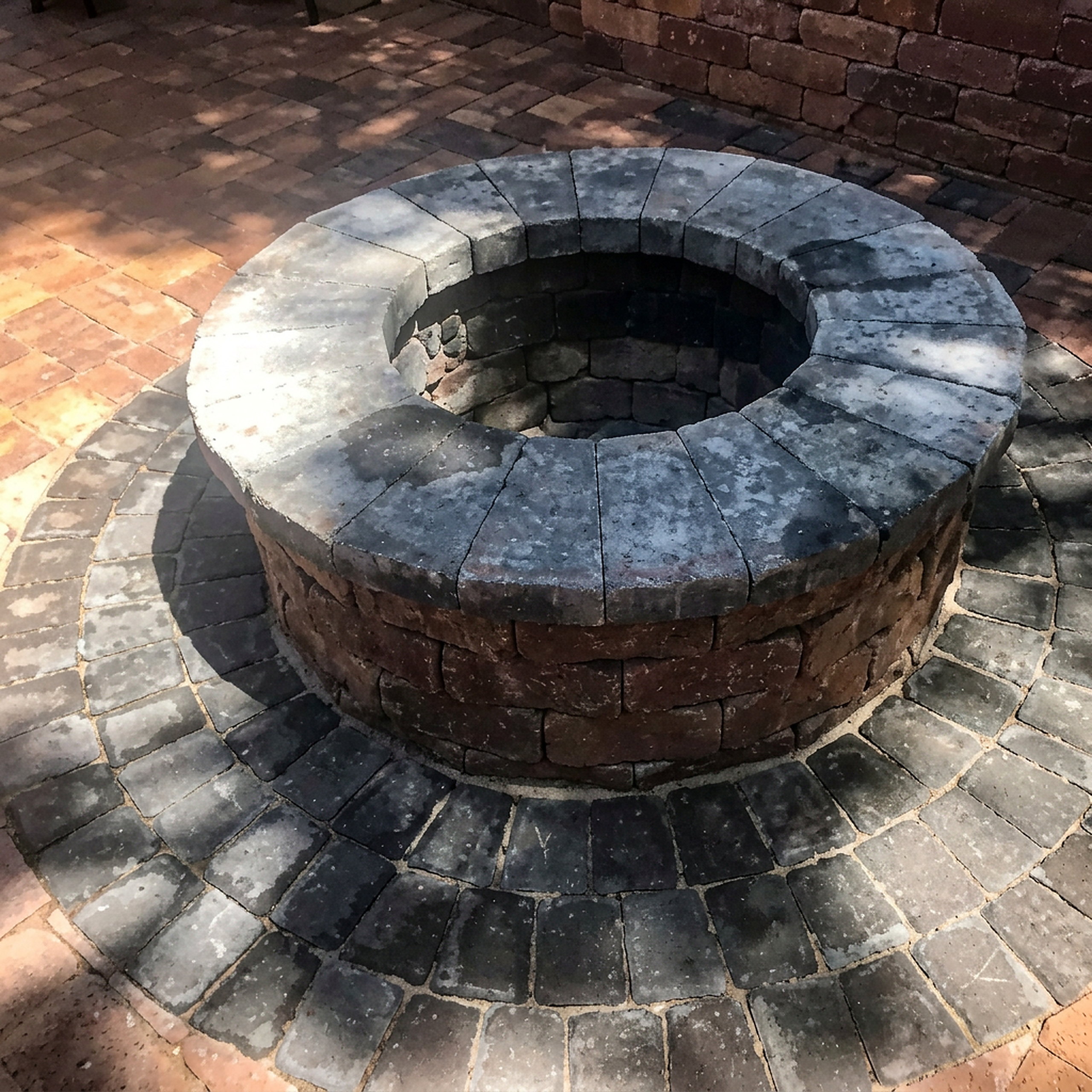 Large round paver fire pit with capped wall